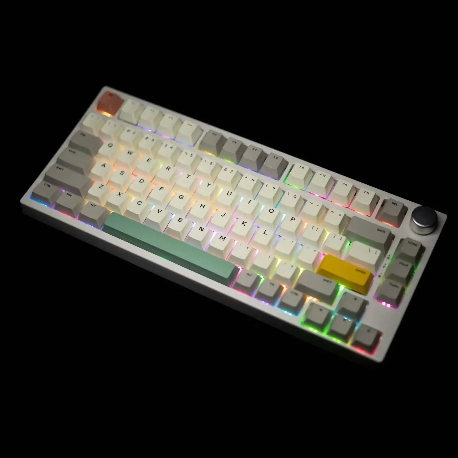 The image shows a gamakay tk75se mechanical keyboard with RGB lighting. The keyboard has a compact layout with white keycpas and a green spacebar. There is a yellow key on the right side and a rotary knob at the top right corner. The RGB lighting is visiable and the keyboard is with the black blackground